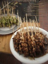 indonesian satay with other marinades and veggies in the background